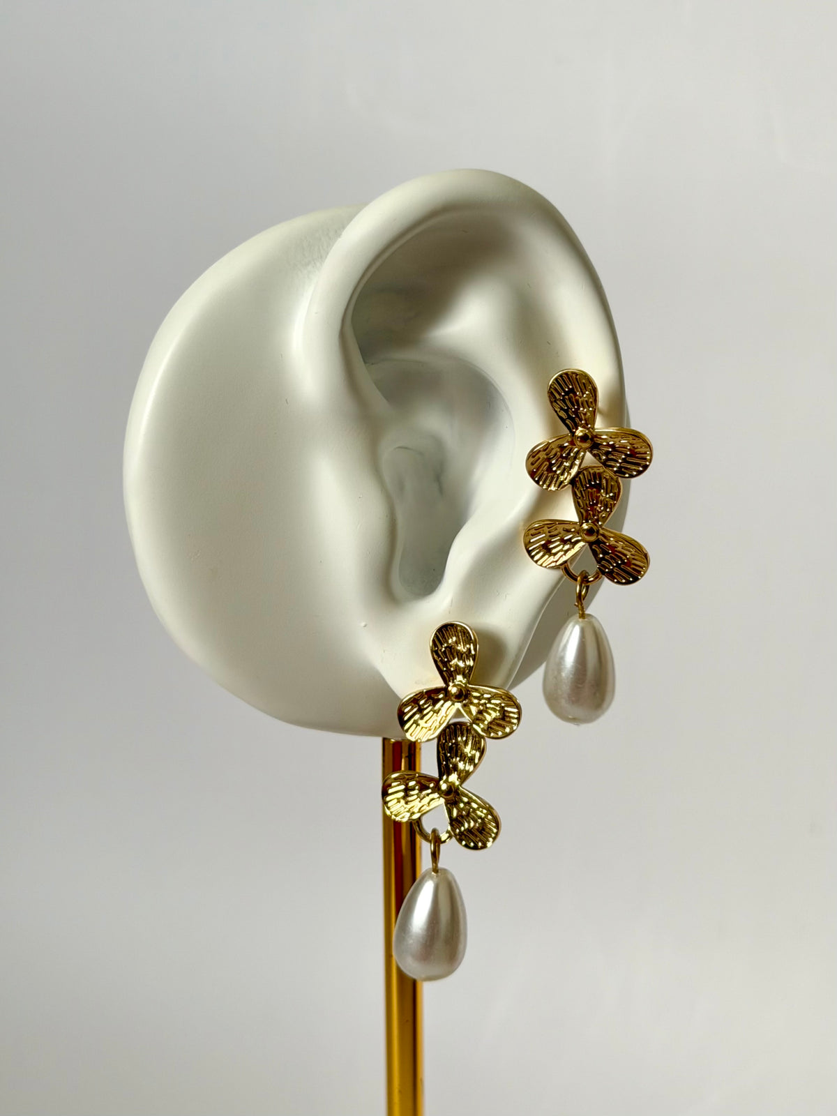 Elodie gold pearl drop earrings worn on ear